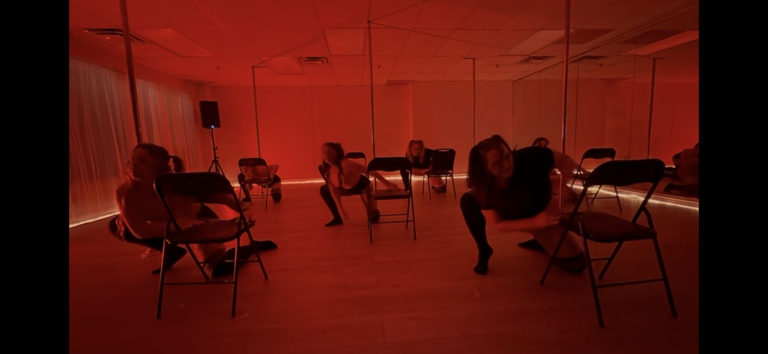 A group chair routine performed under dramatic red stage lighting