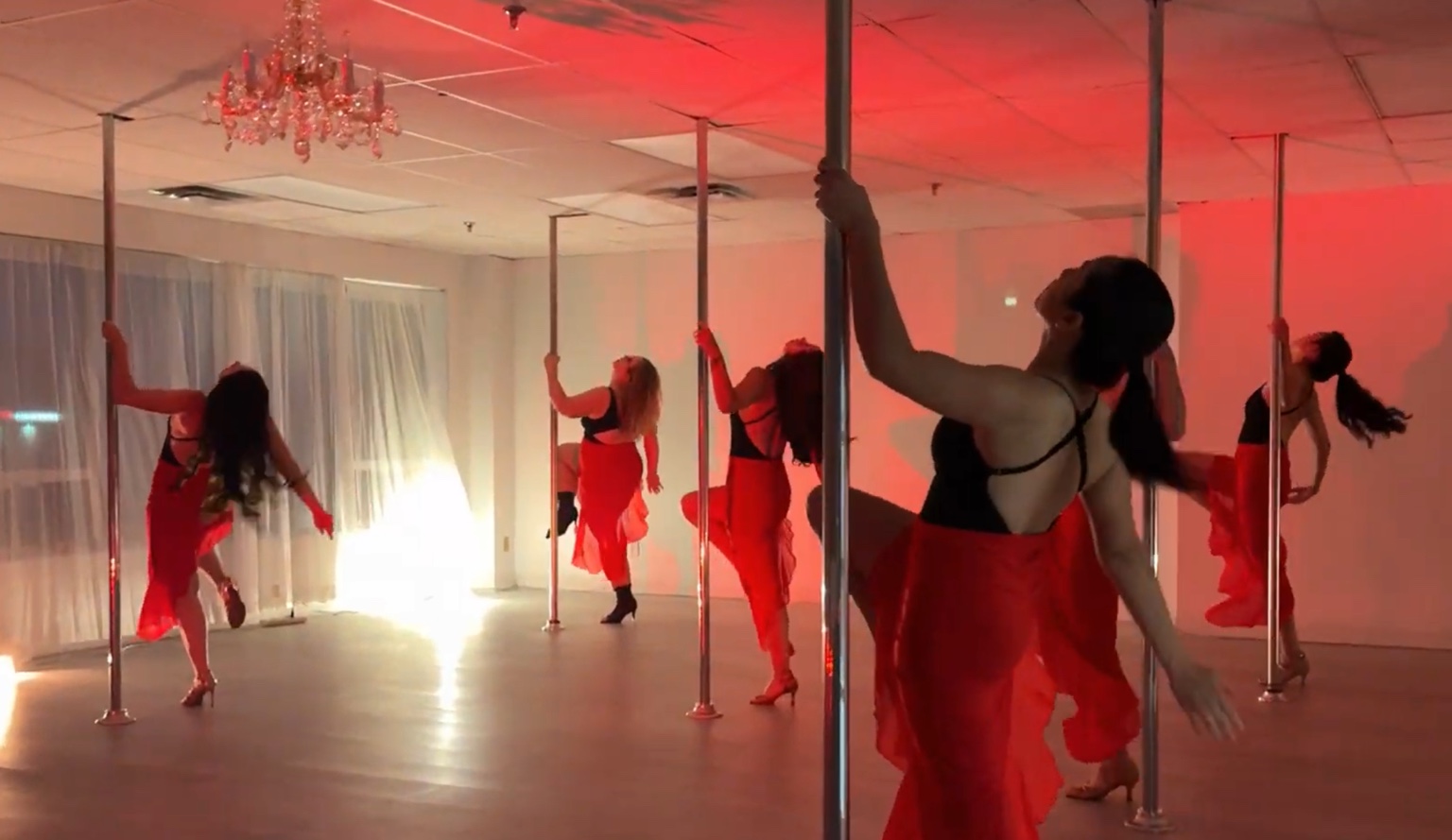 Body Evolution Studios performers in a coordinated red pole routine